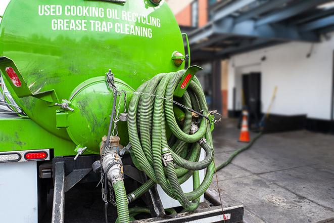 a technician pumping a grease trap in a commercial building in Alden